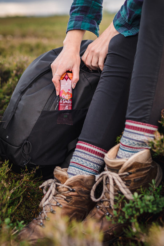 Moonvalley Oats & Dates energibar i ryggsekklomme under tur i naturen
