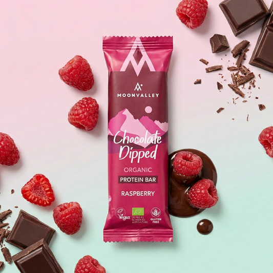 Moonvalley Chocolate Dipped økologisk proteinbar med bringebær sammen med ingrediensene
