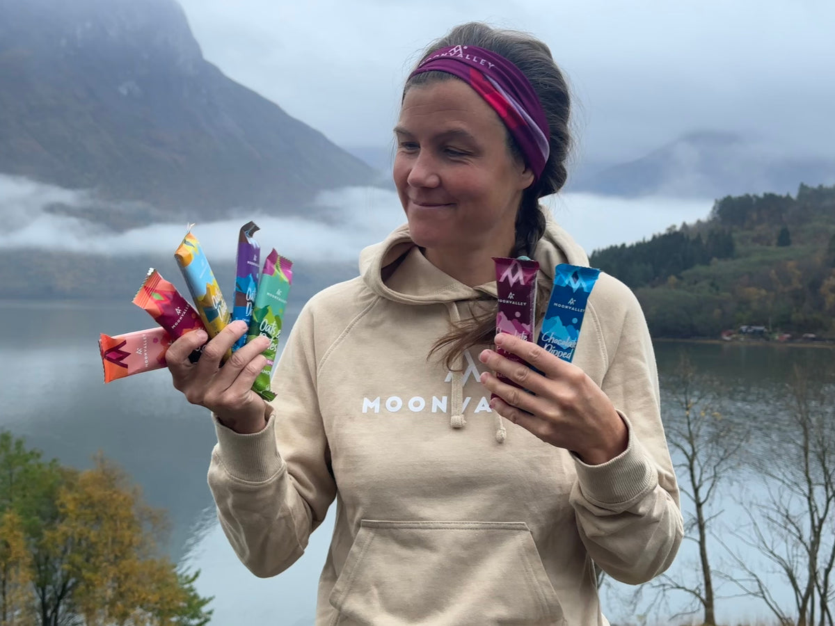 Moonvalleys grunnlegger holder energibarer og proteinbarer ved en fjord i Norge