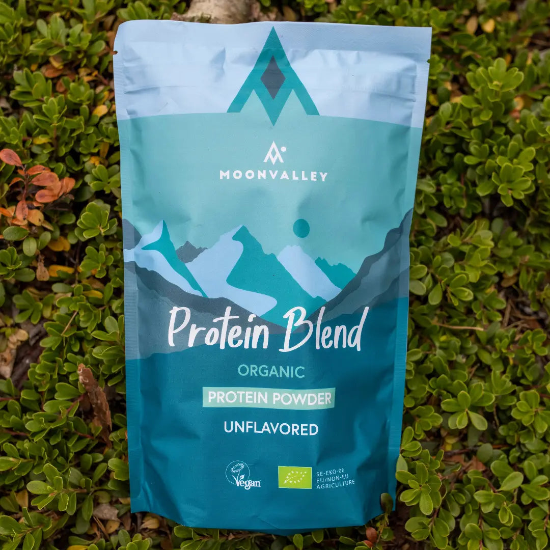 Moonvalley økologisk proteinpulver uten smak i gjenlukkbar pose, fotografert i naturlige omgivelser.