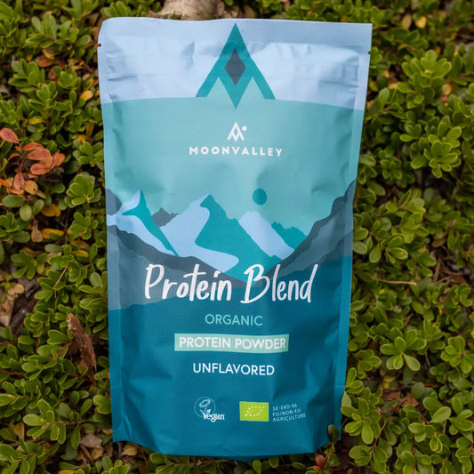 Moonvalley økologisk proteinpulver uten smak i gjenlukkbar pose, fotografert i naturlige omgivelser.